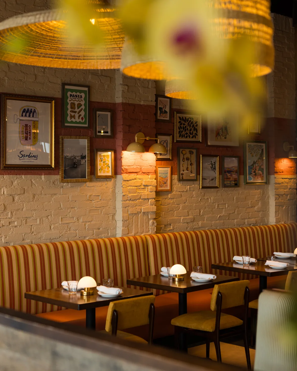 Nimo restaurant dining area with pendant lighting and natural wood tables, Miami interior design by Hybrid Creative